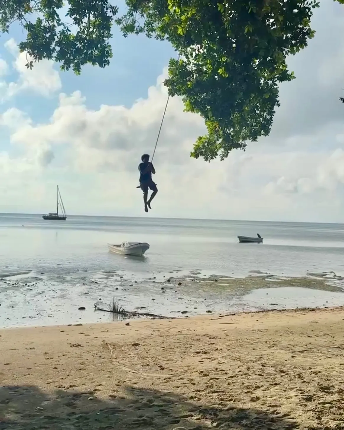 Swinging from a rope over the beach. Swinging from a rope over the beach.