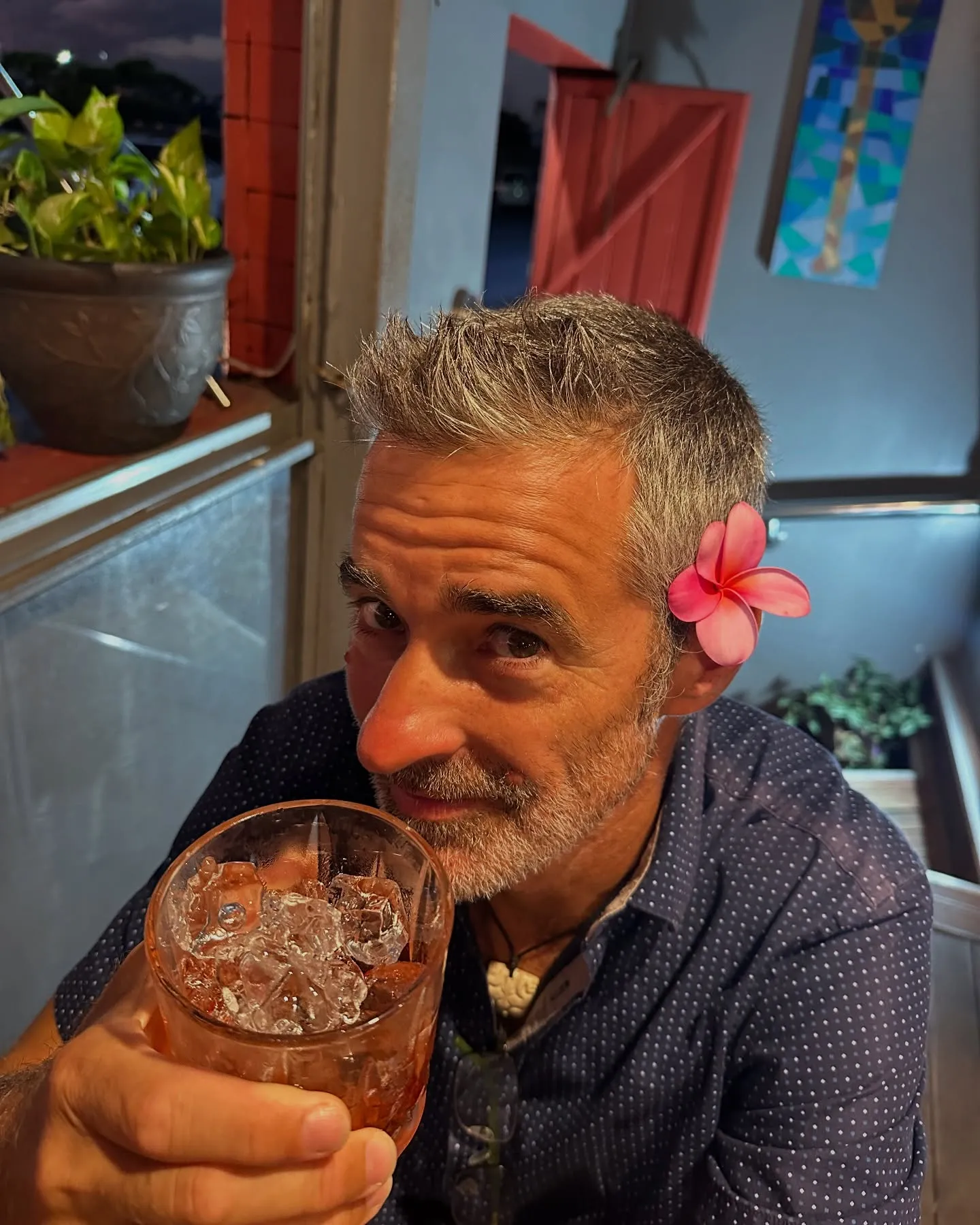 Cheers, with a flower behind the ear.