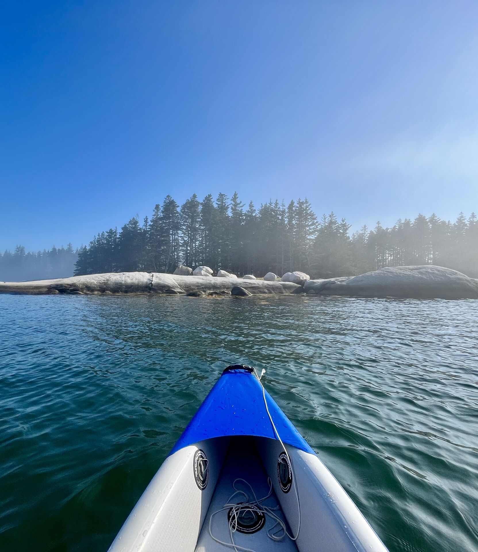 Nothing but trees, rocks, and the waves on the shore.